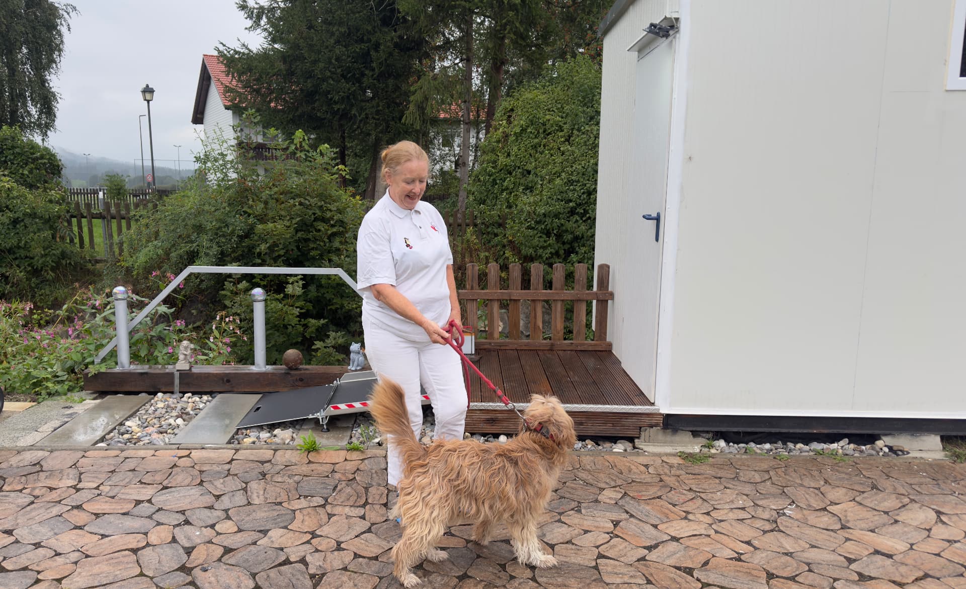 Dr. Astrid Lorenz mit einem Hund vor ihrer Tierarztpraxis in Bernbeuren